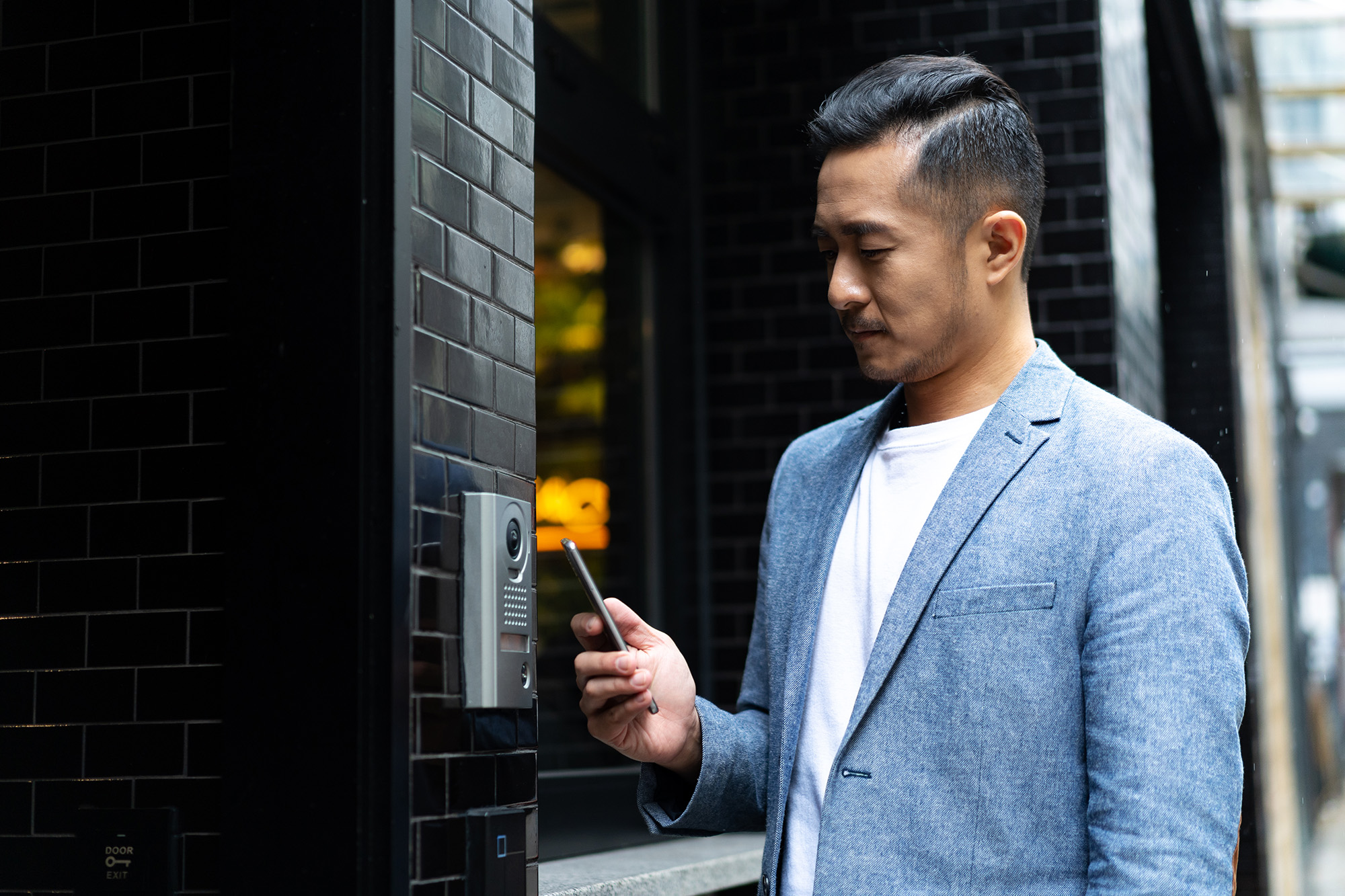 young chinese man using mobile phone unlock door ,smart home