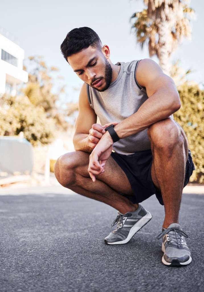 Smart watch, fitness and man on road to check health app, heart rate or exercise progress for body wellness. Sport, clock or runner on digital tech for pulse, training or monitor workout time outdoor.