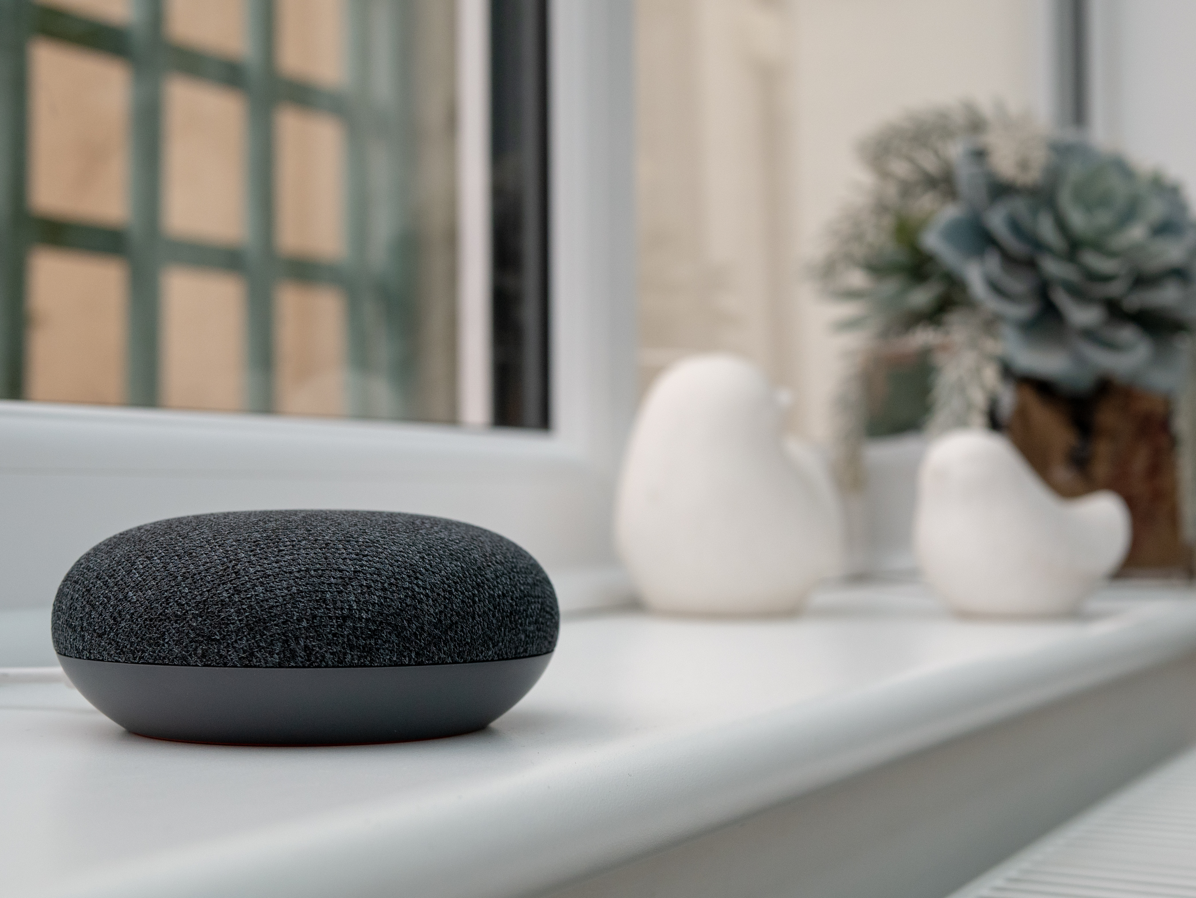 Smart speaker in the foreground on a bench in the home