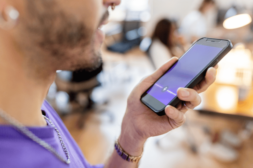 man using his smartphone with voice assistant