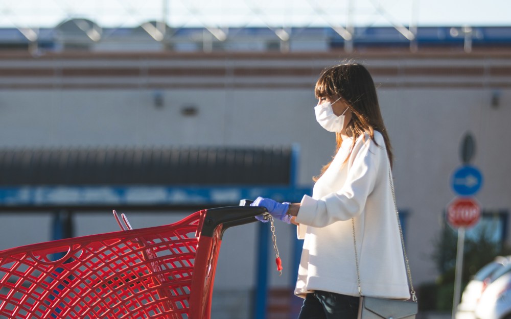 woman with shopping cart wearing mask