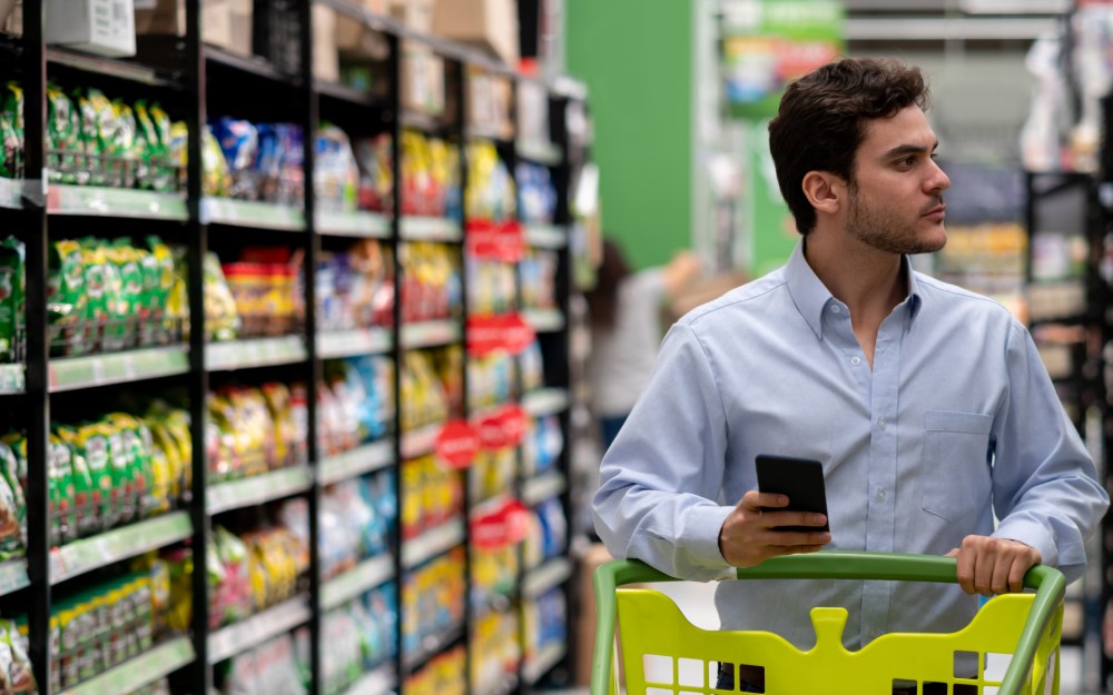 man shopping in supermarket for super bowl snacks