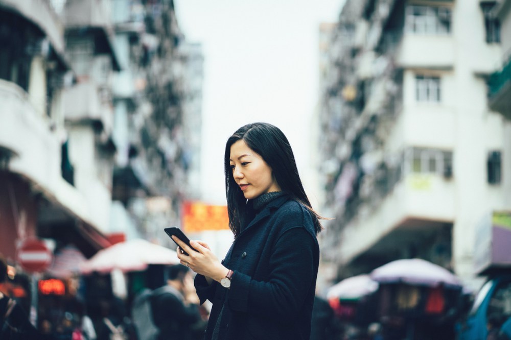 A woman in the Asia Pacific region highlighting an important FMCG trend, e-commerce shopping.
