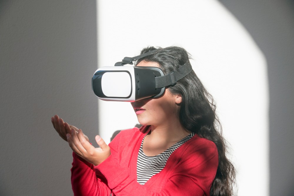 A young woman using a virtual reality headset to enter the metaverse.