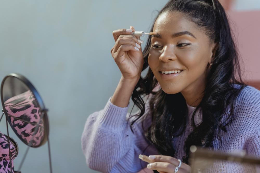 Girl applying makeup to follow beauty trends at school