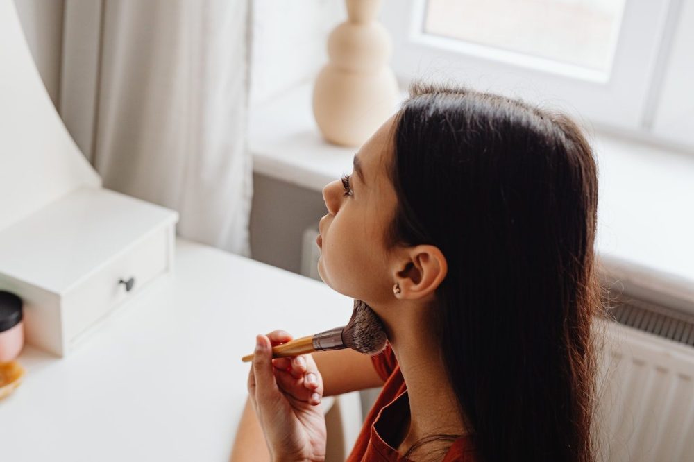 A young Hispanic woman applies beauty products