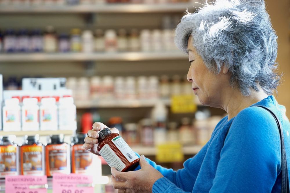 Woman looks at immunity boosting-product in grocery store