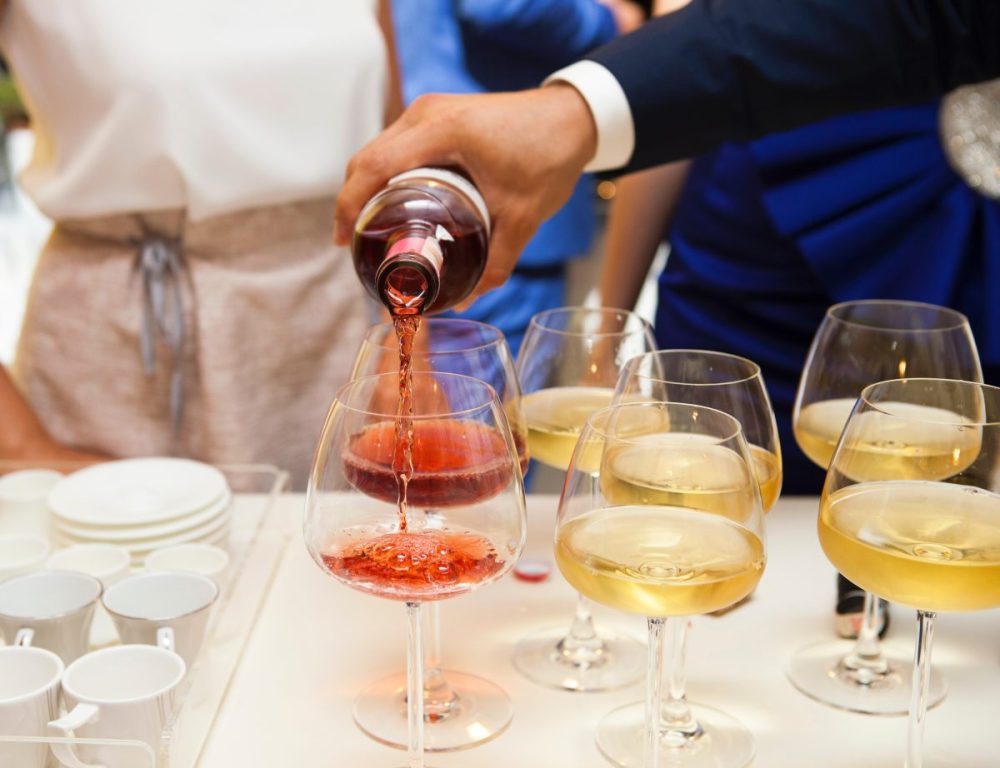 A hand pouring glasses of BFY wine from the bottle.