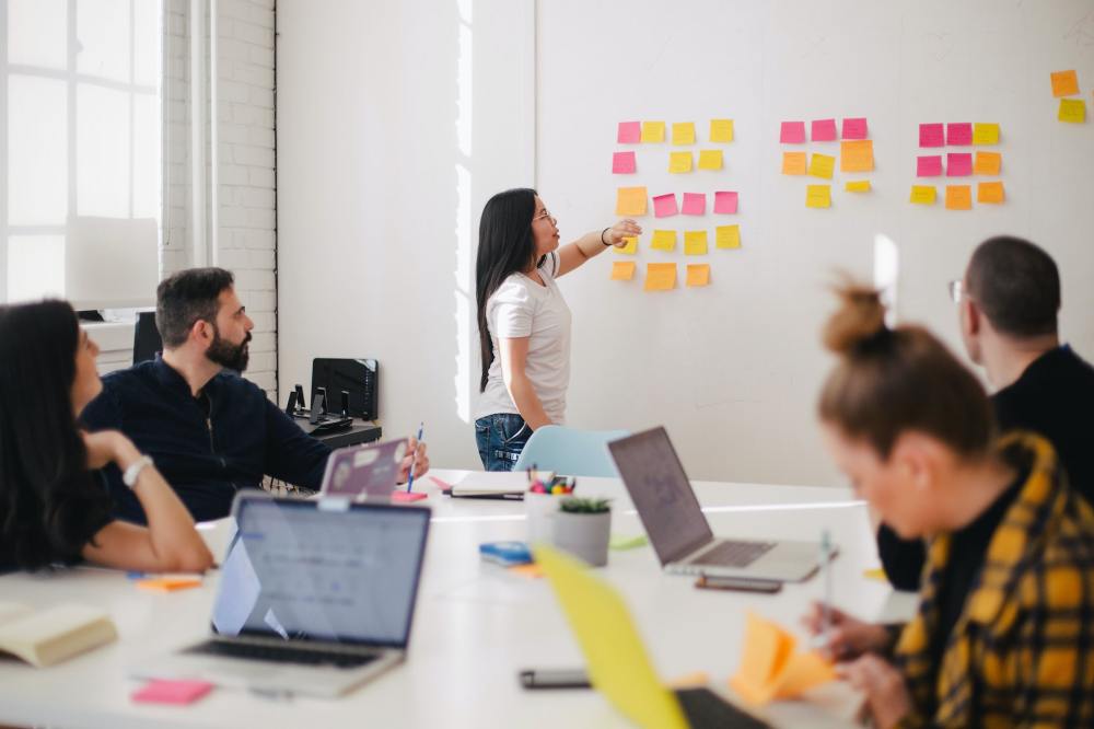 A group of people collaborate in a conference room to unlock innovation success in 2023.