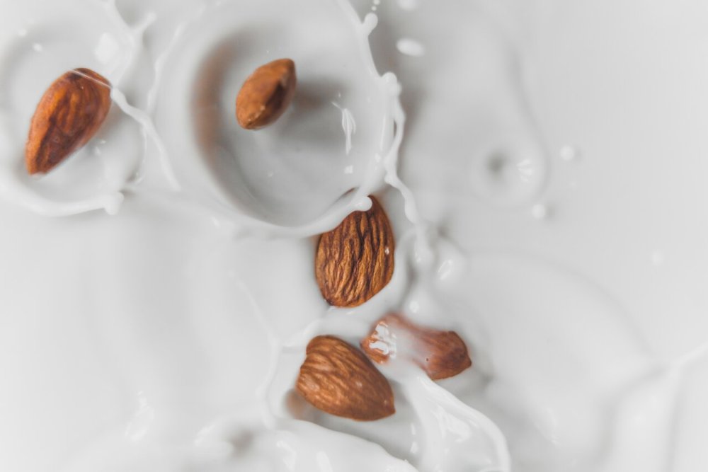 Almonds falling into milk