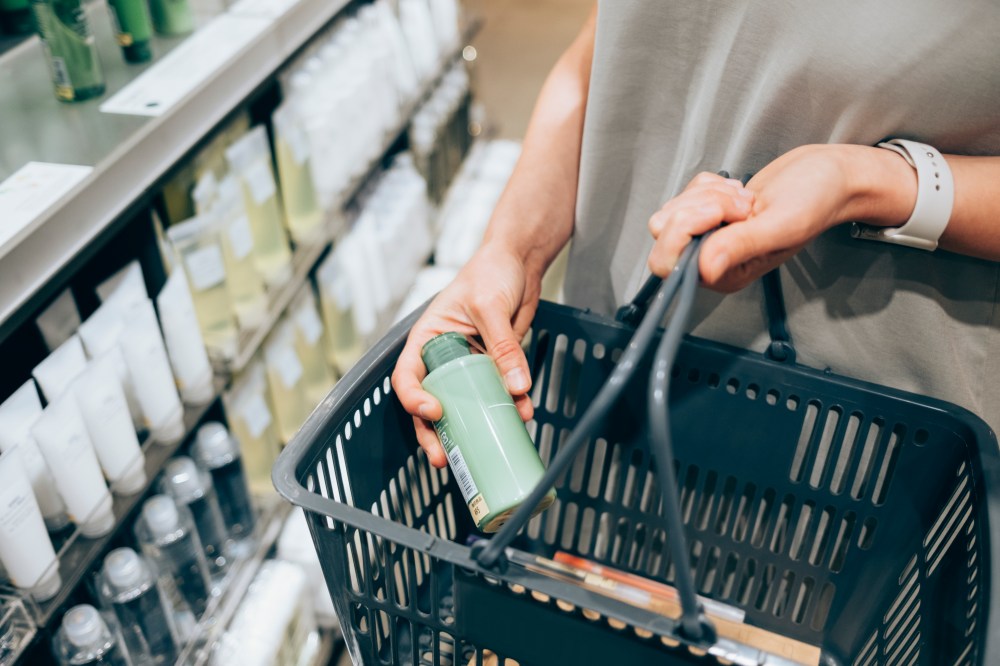 A female customer holding her basket while shopping in-store