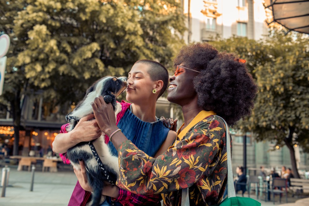 Female couple playing with their dog