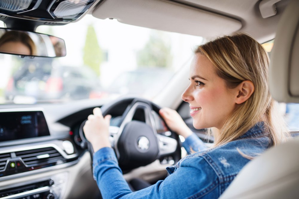 blond woman in a denim shirt driving an electric vehicle