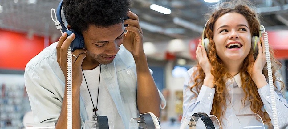 Couple in store listening to music on headphones