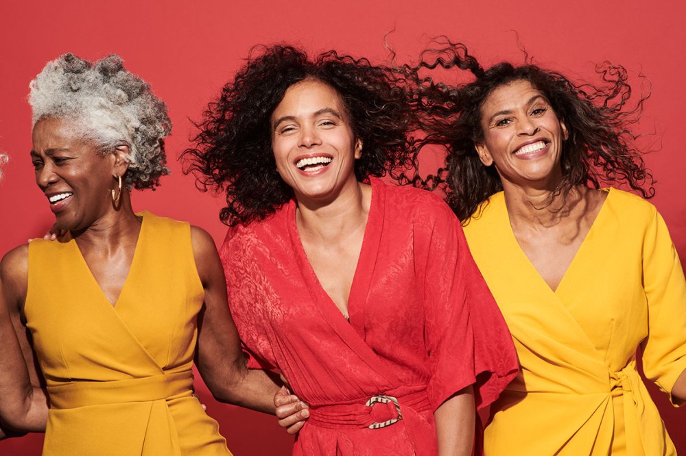 Portrait of a group of mature women against a red background
