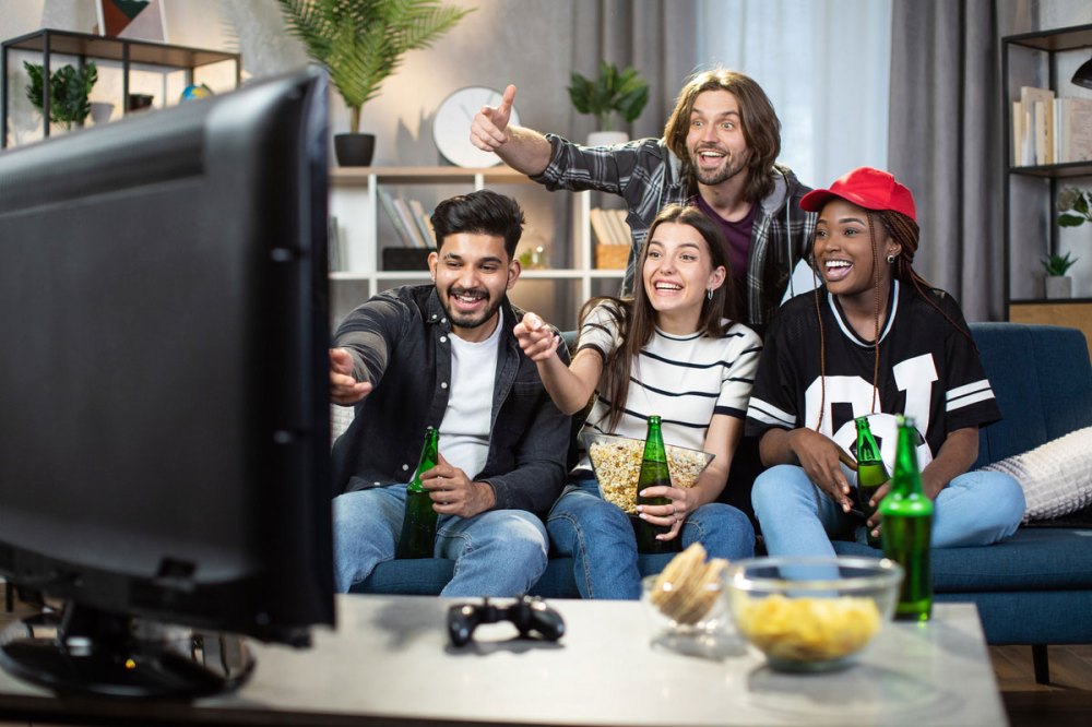 A group of friends watching a sporting event on TV