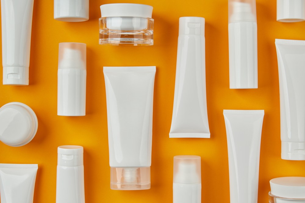 Lotion or cream set on orange background. Care products skincare routine. Body care beauty treatment concept