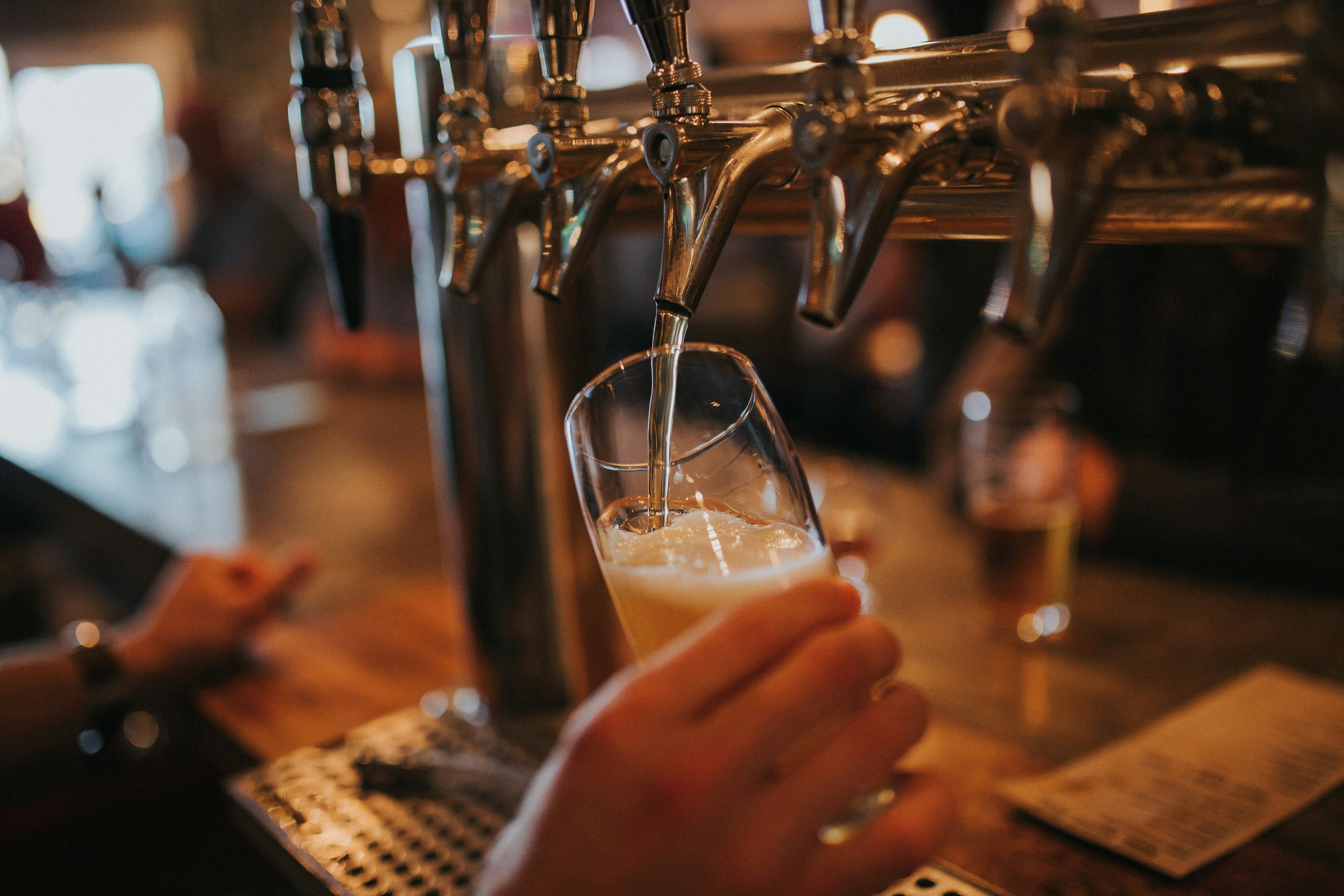 a draft beer being poured in a hospitality venue