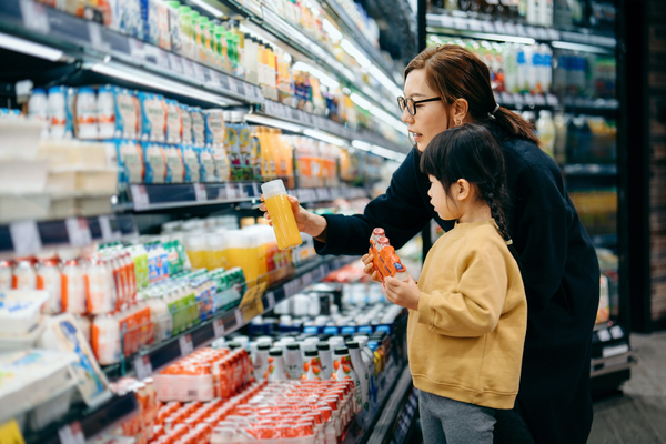 mom and her kid looking at different snacks in a supermarket