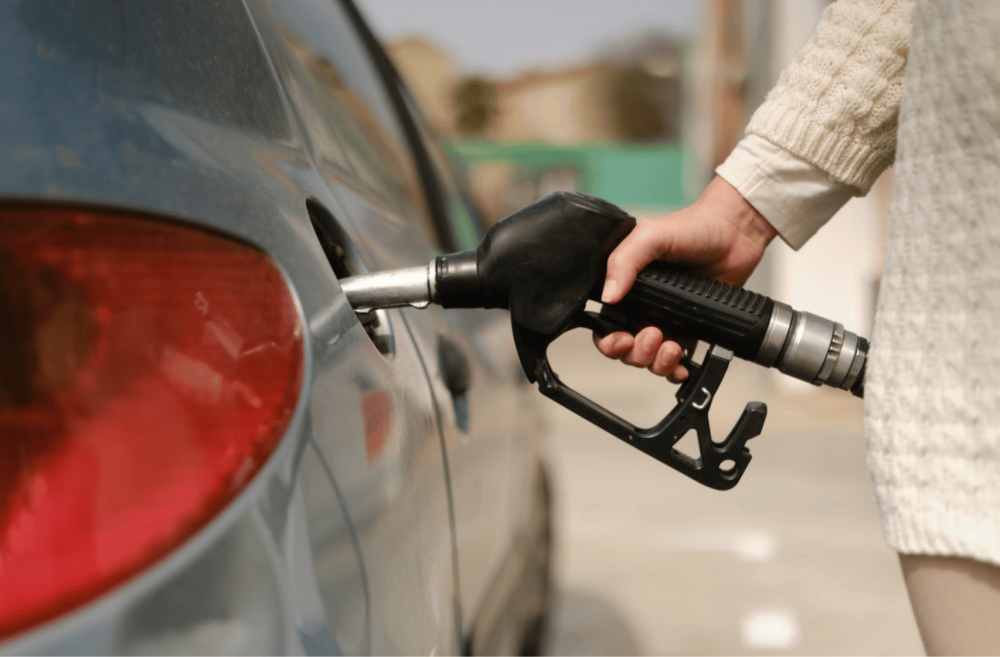 person fueling his car with oil